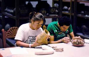 Shaylene Platero (Navajo) and Mathew Naranjo (Santa Clara Pueblo) in a hands-on examination of the IARC pottery