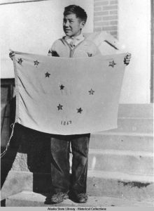 Benny Benson holding the Alaska State Flag